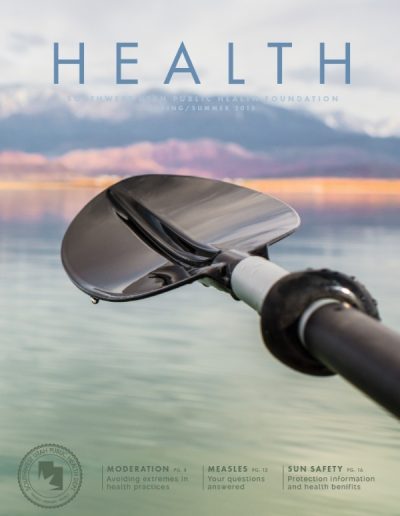Front cover of "HEALTH" magazine, Spring/Summer 2015 issue, featuring a close-up photograph of a shiny black kayak paddle blade resting over a calm body of water.