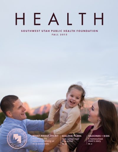 Front cover of "HEALTH" magazine by the Southwest Utah Public Health Foundation, Fall 2015 issue. The photograph captures a joyful moment as a mother and father laugh while lifting up their young, smiling daughter, set against a background of mountains illuminated by sunset light.