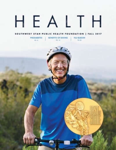 Front cover of "HEALTH" magazine by the Southwest Utah Public Health Foundation, Fall 2017 issue. The main photograph features a smiling, middle-aged man wearing a bike helmet and a blue athletic shirt, holding the handlebars of a bicycle outdoors. A gold "Best of State" medal graphic overlaps the lower right corner.