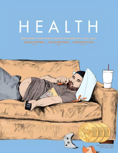 Front cover of "HEALTH" magazine by the Southwest Utah Public Health Foundation, Fall 2019 issue against a solid blue background. The illustration shows a bearded man with an exposed stomach lying on a brown sofa, holding a remote control, eating a snack, and resting his head on a pillow next to a white cup. Text options list articles on "Measles Returns," "Get Off the Couch," and "Nutrition Myths." Three gold "Best of State" medals sit on the floor next to a video game controller.